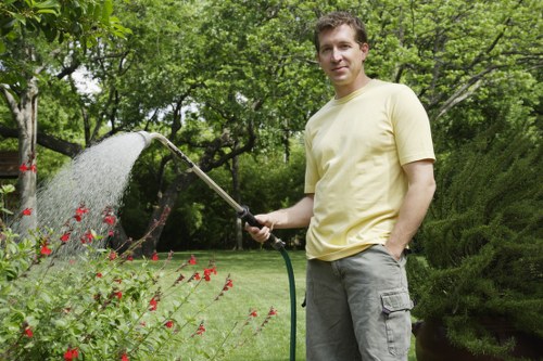 Gardener performing garden maintenance with battery-powered tools